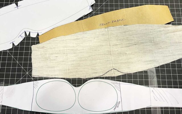 Soft goods factory sample maker constructing a backpack using manufacturing documentation
