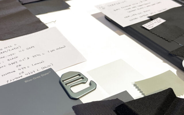 Flat lay showing layered materials and construction elements used in a soft good prototype textile system, including shell fabric, foam, mesh, reinforcement, and webbing.