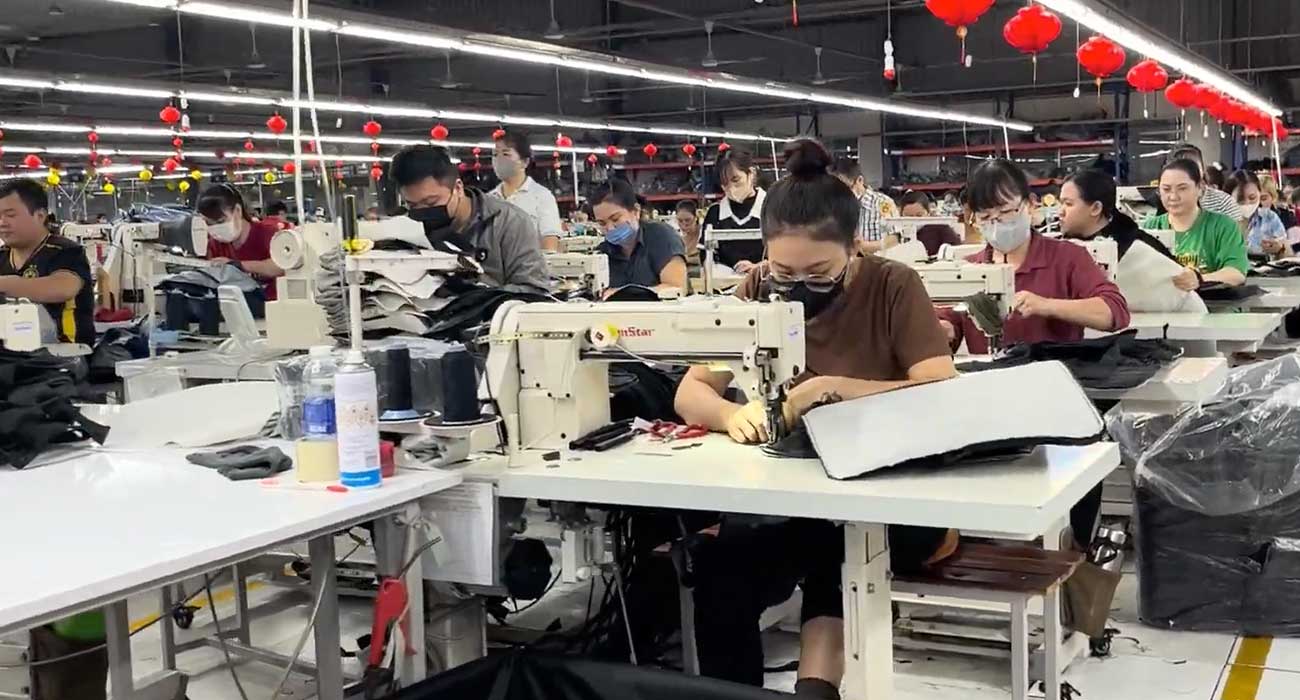 Product designer reviewing soft goods prototypes with manufacturing samples during product development
