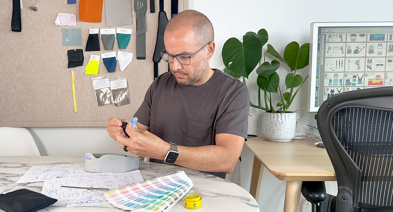 Soft goods product development consultant reviewing technical drawings, materials, and a sewn product prototype.