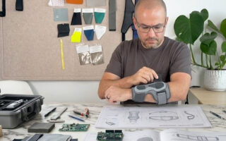 Designer evaluating the fit and comfort of a wearable technology prototype on a test user.